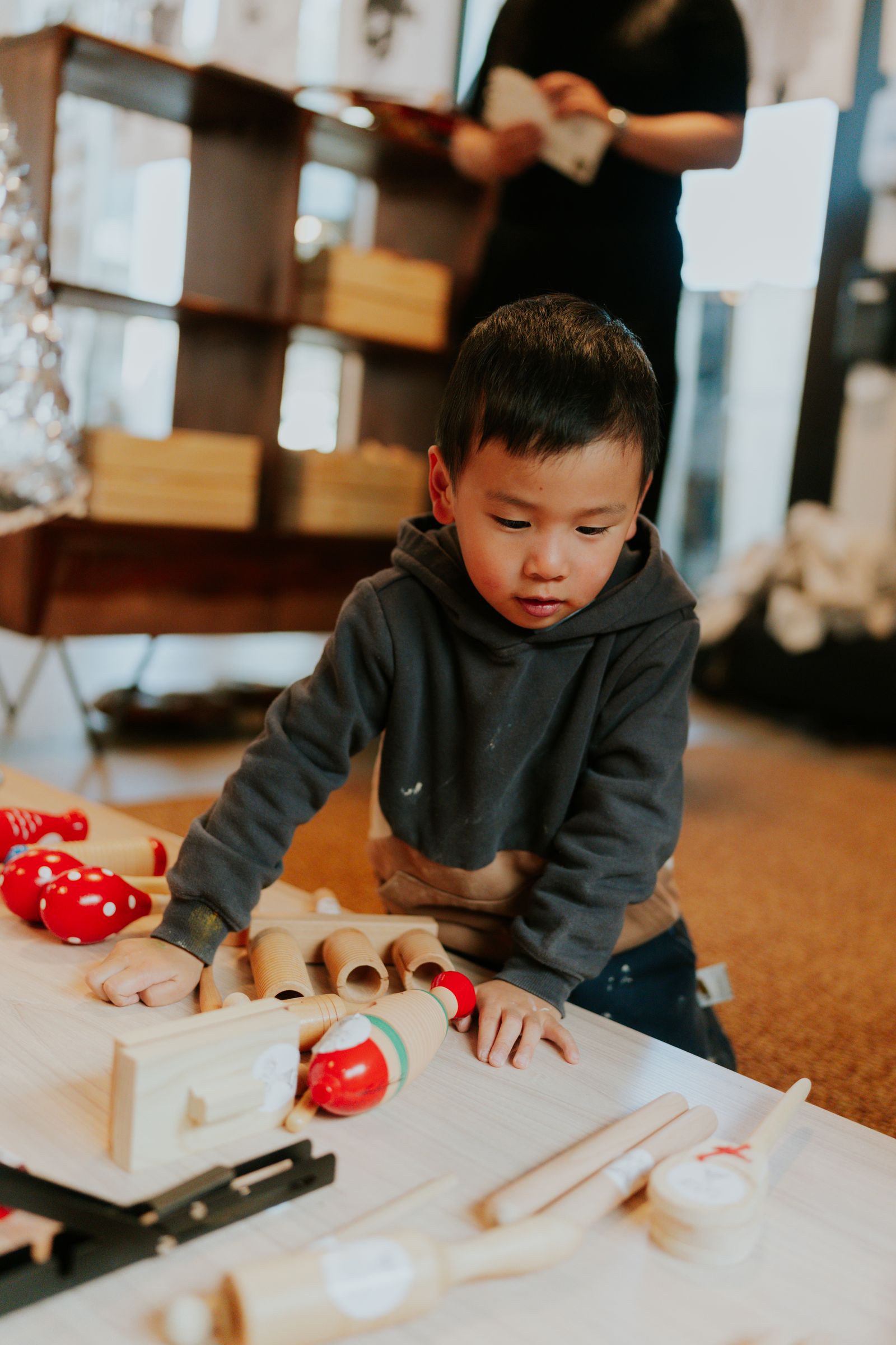 A child sorts loose wooden pieces at a table